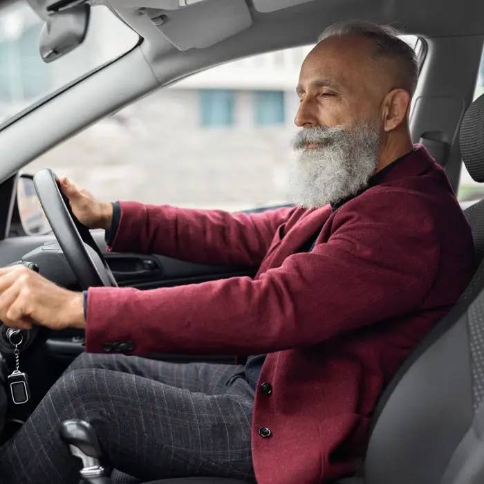 senior man driver turning on music in car before m UW3CELZ